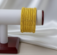 Gold bracelet on a white mannequin arm with a white background
