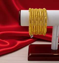 Gold bracelet on a white stand against a red satin background


