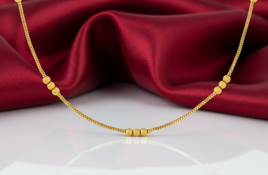 Gold necklace on a red fabric background
